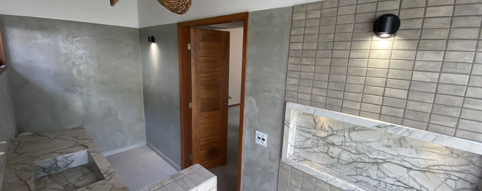 Banheiro com bancada e revestimento de pedra